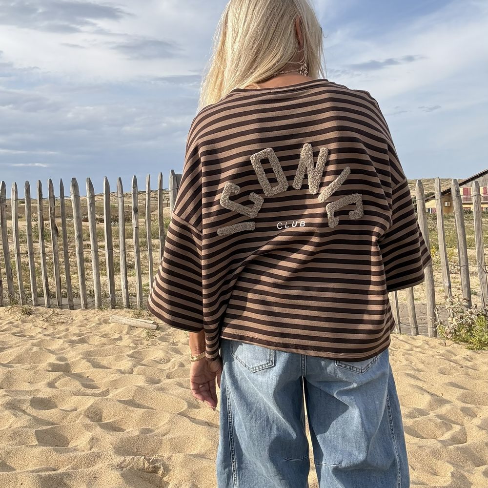 Broderie iconic beige dans le dos du sweat marinière, gros plan